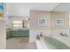 Well-lit bathroom with a bathtub, vanity, and a large mirror at 10575 Sw 27Th Ave, Ocala, FL 34476