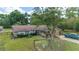 Exterior view of the home featuring a front yard with mature trees and a swing set at 10575 Sw 27Th Ave, Ocala, FL 34476