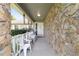 Stone-clad front porch with a white railing and a cozy sitting area at 10575 Sw 27Th Ave, Ocala, FL 34476