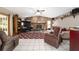 Cozy living room with a stone fireplace, ceiling fan, and neutral furniture at 10575 Sw 27Th Ave, Ocala, FL 34476