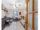 Home office with built-in shelves, desk, ceiling fan, and wood-look glass panel doors at 10575 Sw 27Th Ave, Ocala, FL 34476