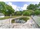 Backyard with a swimming pool, surrounded by mature trees and a spacious green area at 10575 Sw 27Th Ave, Ocala, FL 34476