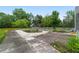 Backyard pool with concrete patio needing some repairs, surrounded by mature trees and vegetation at 10575 Sw 27Th Ave, Ocala, FL 34476