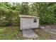 Exterior shot of white storage shed surrounded by lush greenery at 10575 Sw 27Th Ave, Ocala, FL 34476