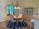 Inviting dining room featuring elegant chandelier and a large window providing ample natural light, complemented by a stylish rug at 10918 Sw 71St Cir, Ocala, FL 34476