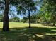 Scenic golf course view with mature trees and a sand trap in the distance at 10918 Sw 71St Cir, Ocala, FL 34476