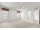 Bright bedroom with a ceiling fan, neutral carpet, and large windows offering ample natural light and a spacious feel at 11058 Sw 69Th Cir, Ocala, FL 34476