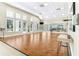 Spacious flex area featuring wood floors, natural light, and mirrors for activities at 11058 Sw 69Th Cir, Ocala, FL 34476