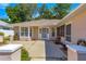 A inviting entrance that features a well lit doorway and a low wall surrounding the front yard at 11058 Sw 69Th Cir, Ocala, FL 34476