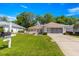 Charming home featuring a well-manicured lawn and a convenient screened-in two-car garage at 11058 Sw 69Th Cir, Ocala, FL 34476
