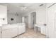 Well-lit kitchen featuring tile flooring, white cabinetry, and an adjacent desk area at 11058 Sw 69Th Cir, Ocala, FL 34476