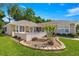 Front yard featuring lush lawn, flower beds and manicured shrubs adding to the home's curb appeal at 11058 Sw 69Th Cir, Ocala, FL 34476