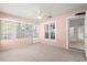 Bright sunroom features neutral carpet, a ceiling fan, and multiple windows allowing natural light to flood the space at 11058 Sw 69Th Cir, Ocala, FL 34476