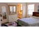 Cozy bedroom with a decorative mirror and doorway to a bathroom at 11591 Sw 78Th Ave, Ocala, FL 34476