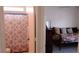 View into a bedroom from the hallway next to a bathroom with a patterned shower curtain at 11591 Sw 78Th Ave, Ocala, FL 34476