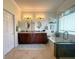 Bright bathroom features a double vanity, decorative mirrors, soaking tub, and walk-in shower with glass door at 13111 Se 86Th Cir, Summerfield, FL 34491