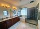 Bright bathroom featuring a dual sink vanity, soaking tub, and walk-in glass shower at 13111 Se 86Th Cir, Summerfield, FL 34491