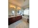 Bright bathroom featuring a dual sink vanity, soaking tub, and neutral tile flooring at 13111 Se 86Th Cir, Summerfield, FL 34491