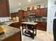 Kitchen featuring granite countertops, custom cabinets, an island, and stainless steel appliances at 13111 Se 86Th Cir, Summerfield, FL 34491