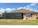 Back of house view featuring the screened porch and lush landscaping at 13111 Se 86Th Cir, Summerfield, FL 34491