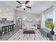 Bright living room with modern decor, ceiling fan, light-colored walls, and an adjacent kitchen area at 13185 Sw 83Rd Terrace Rd, Ocala, FL 34473