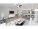 Stylish living room with an open layout, wood-look floors, modern furniture, and a view into the kitchen and dining area at 13185 Sw 83Rd Terrace Rd, Ocala, FL 34473