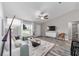 Bright, airy living room featuring a ceiling fan, large windows, and an open layout to the dining and kitchen areas at 13185 Sw 83Rd Terrace Rd, Ocala, FL 34473