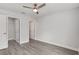 Comfortable bedroom with wood-look floors, a ceiling fan, and access to closets and other rooms at 13300 Sw 105Th Pl, Dunnellon, FL 34432