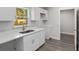 Well-lit kitchen with white cabinets, granite countertops, stainless steel sink, and views to the exterior at 13300 Sw 105Th Pl, Dunnellon, FL 34432