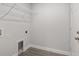 This laundry room features a floor drain, wire shelf, gray flooring, and white walls at 13300 Sw 105Th Pl, Dunnellon, FL 34432