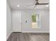 Bright room with neutral paint, a ceiling fan, gray flooring, a window and a white door at 13300 Sw 105Th Pl, Dunnellon, FL 34432
