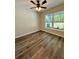Well-lit bedroom featuring wood-look flooring, ceiling fan, and a window offering natural light at 13518 Sw 114Th Ln, Dunnellon, FL 34432