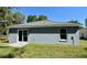Back exterior of the home featuring a patio, sliding glass doors, and grassy yard at 13518 Sw 114Th Ln, Dunnellon, FL 34432
