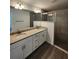 Bathroom featuring double sinks with a granite countertop, white cabinets, and a tiled glass shower at 1475 Sw Big Bear Rdg, Dunnellon, FL 34431