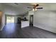Spacious living room featuring gray floors, white walls and an open floorplan to the kitchen at 1475 Sw Big Bear Rdg, Dunnellon, FL 34431