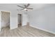 Bedroom with ceiling fan, wood-look floors, and view into bathroom with marbled shower at 15067 Sw 16 Pl, Ocala, FL 34481