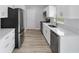 Well-lit kitchen showcasing stainless steel appliances, quartz counters and wood-look floors at 15067 Sw 16 Pl, Ocala, FL 34481
