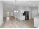 Open-concept living area with modern lighting, wood-look floors, and stainless-steel refrigerator at 15067 Sw 16 Pl, Ocala, FL 34481