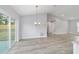 Living room featuring modern chandelier, vaulted ceilings, and sliding glass doors at 15067 Sw 16 Pl, Ocala, FL 34481
