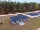 New single-Gathering home with a modern gray exterior, a dark roof, and a concrete patio on a large lot at 15071 Sw 16 Pl, Ocala, FL 34481