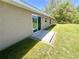 Home's backyard featuring a sliding glass door, a small concrete patio and a grass lawn at 15585 Sw 46Th Cir, Ocala, FL 34473