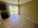 Bright dining room featuring tiled floors, slider to the backyard, and contemporary chandelier at 15585 Sw 46Th Cir, Ocala, FL 34473