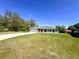 Single-story home with an attached garage, surrounded by lush greenery at 15585 Sw 46Th Cir, Ocala, FL 34473