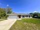 Traditional single-story home with a two-car garage and a red front door at 15585 Sw 46Th Cir, Ocala, FL 34473