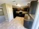 Modern kitchen featuring dark cabinets, granite countertops, black appliances, and tile flooring at 15585 Sw 46Th Cir, Ocala, FL 34473