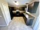 Modern kitchen featuring dark cabinets, granite countertops, black appliances, and tile flooring at 15585 Sw 46Th Cir, Ocala, FL 34473