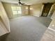 Bright living room featuring neutral carpet, a ceiling fan, and a front entrance with natural lighting at 15585 Sw 46Th Cir, Ocala, FL 34473