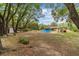 A large backyard surrounded by mature trees with an above ground pool and small shed at 16405 Se 90Th Ct, Summerfield, FL 34491