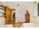 Cozy bedroom showcasing twin beds, wood flooring, and a closet with bi-fold doors at 16405 Se 90Th Ct, Summerfield, FL 34491