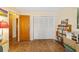 Neutral-toned bedroom features wood floors, closet with bi-fold doors, and bright natural light at 16405 Se 90Th Ct, Summerfield, FL 34491